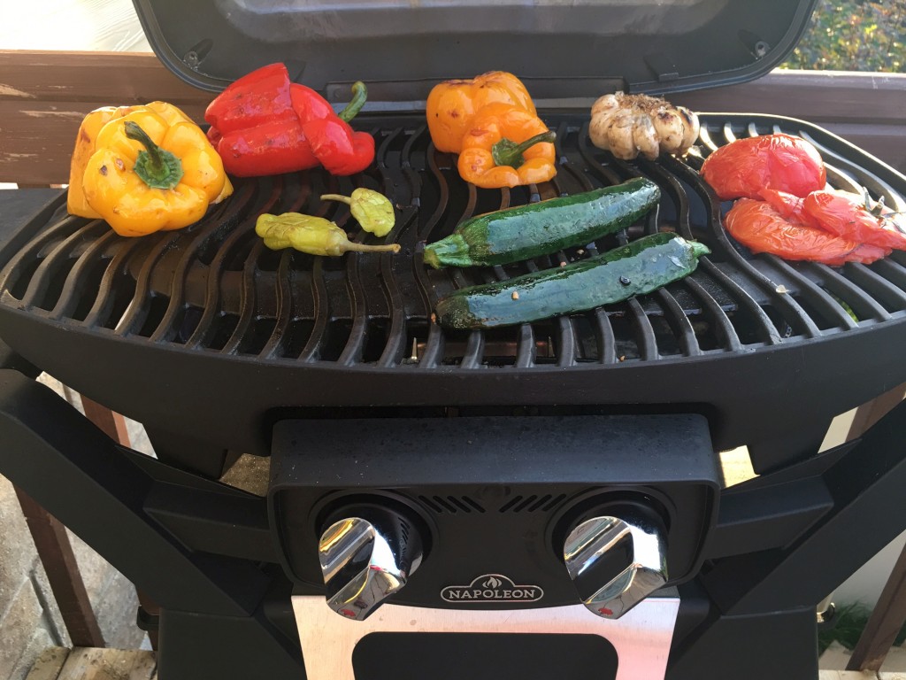 Légumes (poivron, ail, tomates, courgettes) sur un barbecue Napoléon