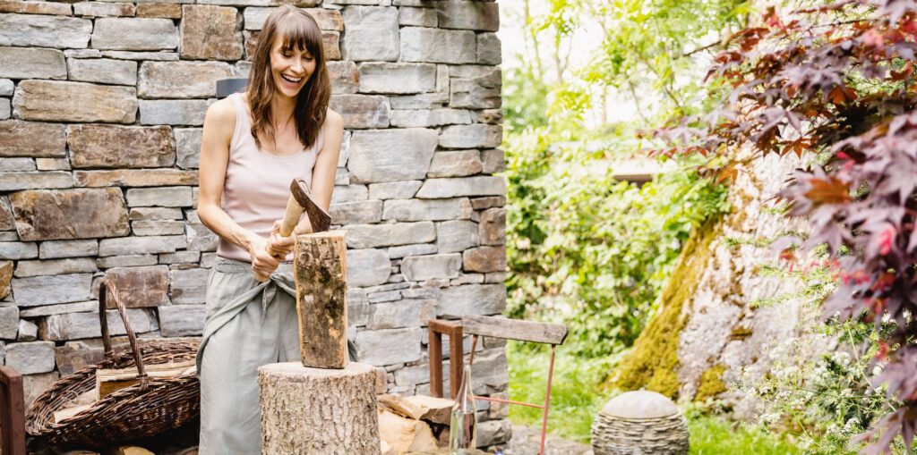 Liste de choses à faire avant d'allumer votre première attisée de la saison - Une femme coupe du bois