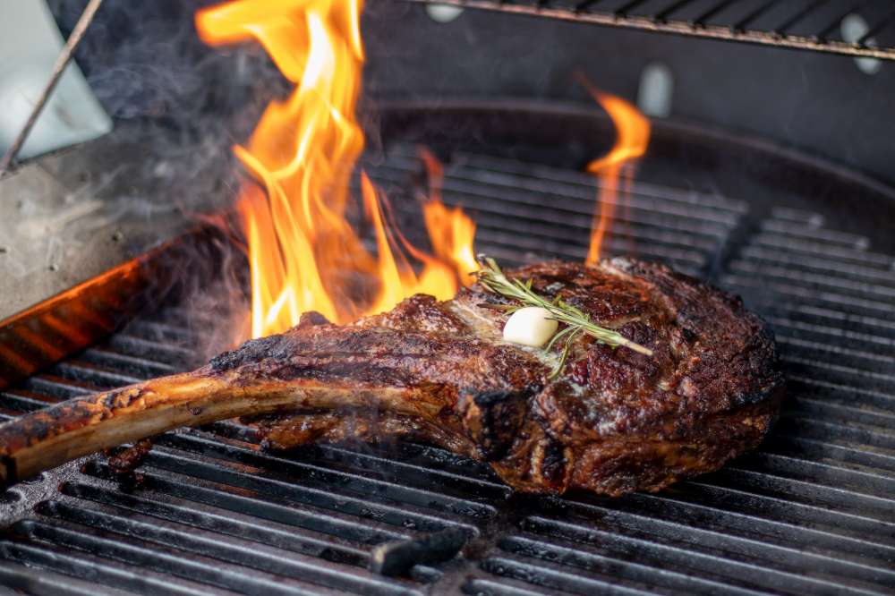 Chef-d'œuvre culinaire, le steak Tomahawk sur le gril avec romarin et beurre. Comment cuire le parfait steak Tomahawk?