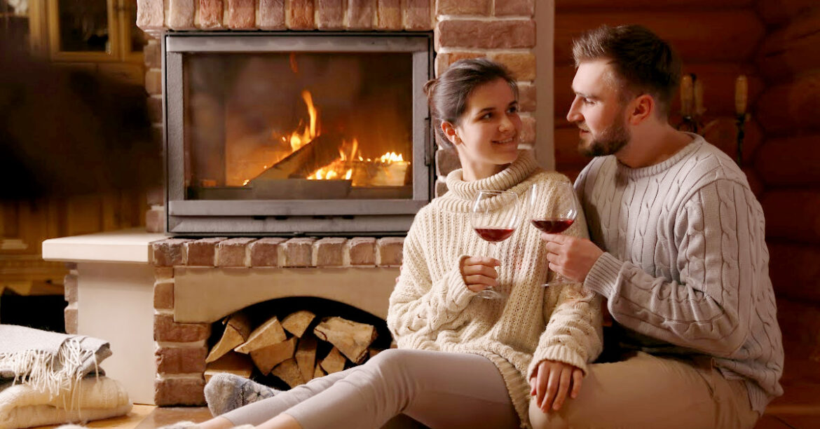 La Romance de l'Hiver : Idées de Soirées en Amoureux au Coin du Foyer- un couple danse au bord du feu - un couple fait une soiree romantique au bord du feu