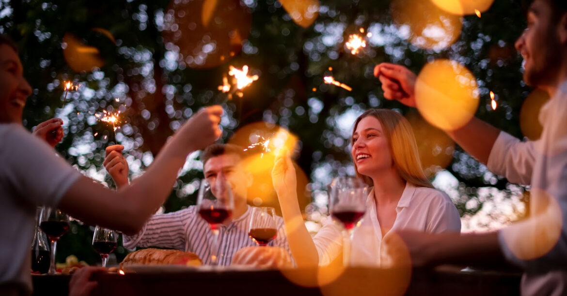 Un groupe d'amis prennent un bon repas dehors un soir d'ete